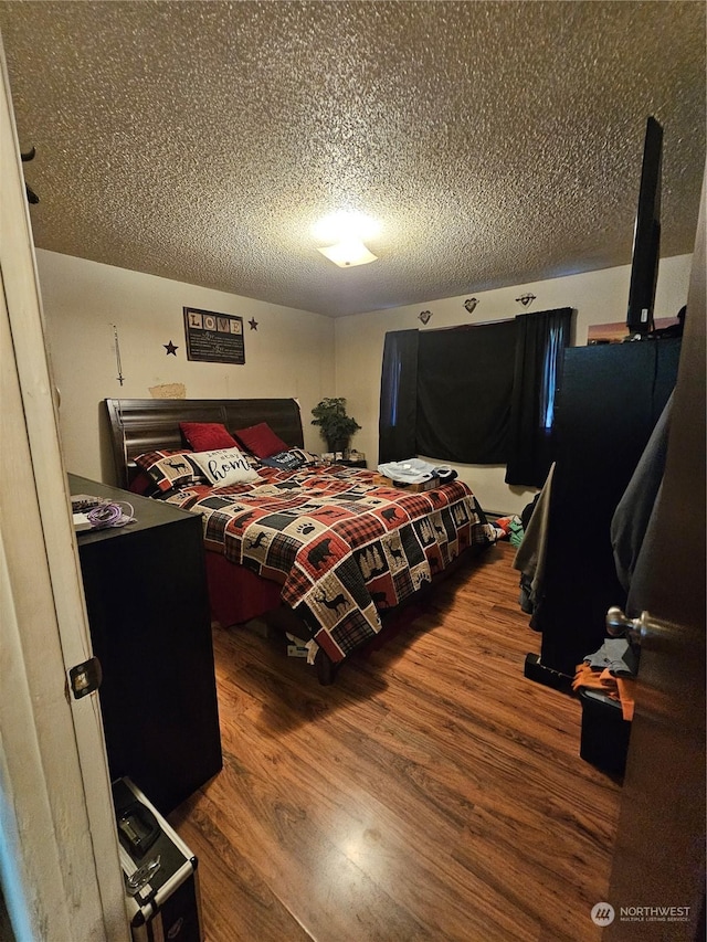 bedroom featuring hardwood / wood-style flooring and a textured ceiling