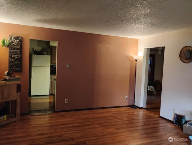 spare room featuring dark hardwood / wood-style flooring and a textured ceiling