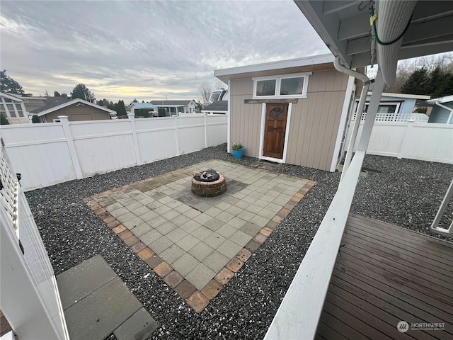 patio terrace at dusk with a wooden deck and a fire pit