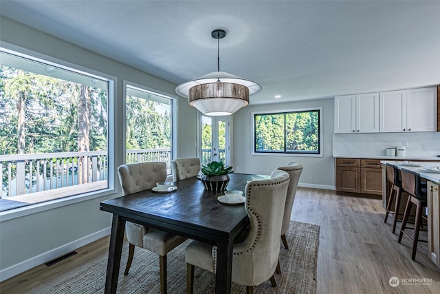 dining space featuring light wood-type flooring and french doors