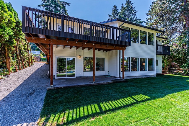 rear view of house featuring a yard, a patio, and a wooden deck