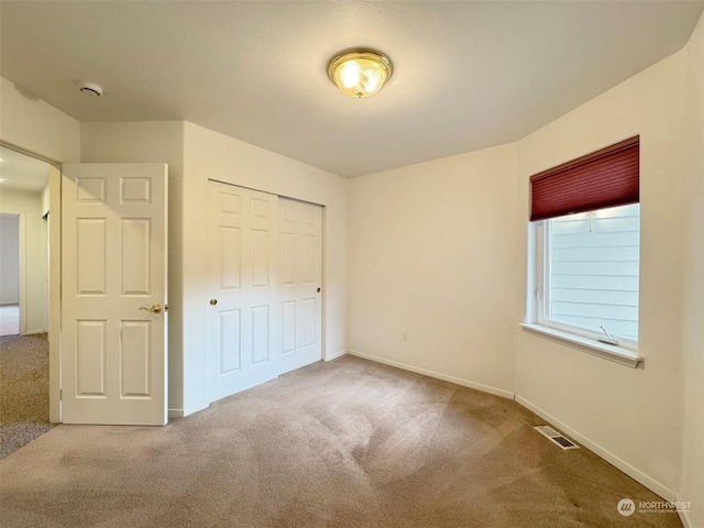 unfurnished bedroom featuring carpet flooring and a closet