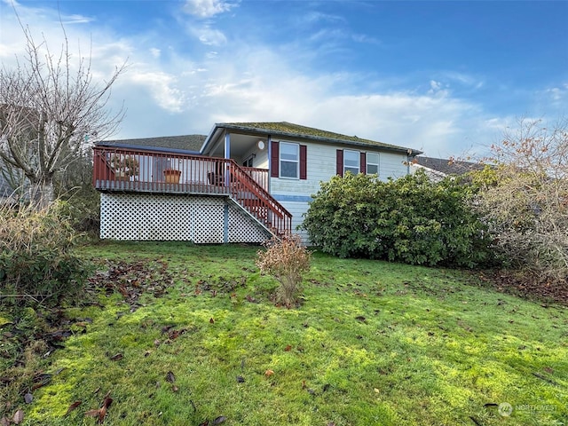 rear view of house featuring a lawn and a wooden deck