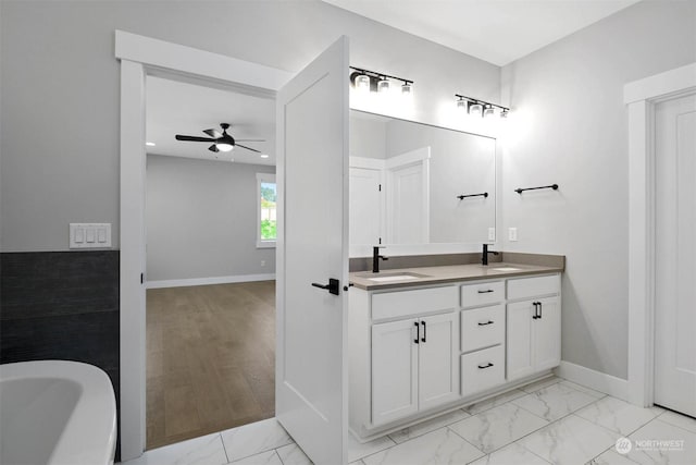 bathroom with hardwood / wood-style floors, ceiling fan, a bath, and vanity