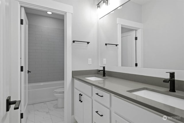 full bathroom featuring tiled shower / bath, vanity, and toilet