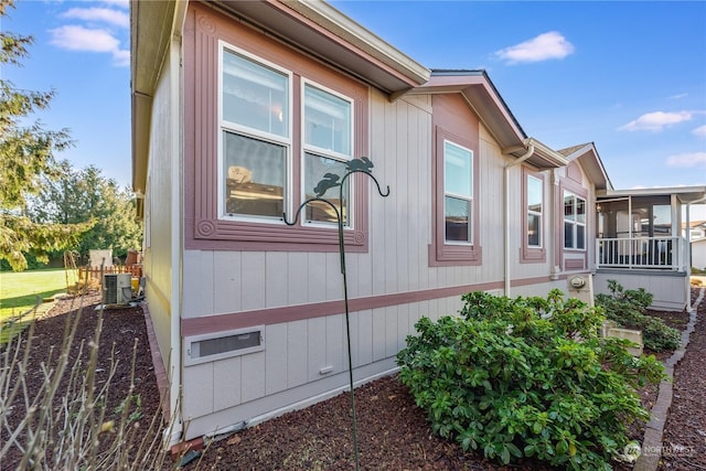 view of property exterior with a sunroom and cooling unit