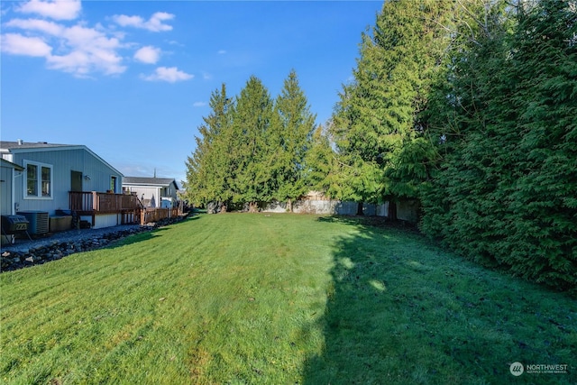 view of yard featuring central AC unit and a deck