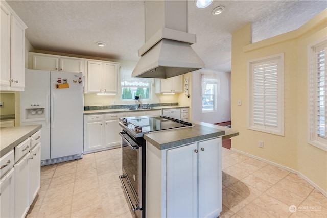 kitchen featuring stainless steel range with electric stovetop, sink, white fridge with ice dispenser, a textured ceiling, and white cabinetry