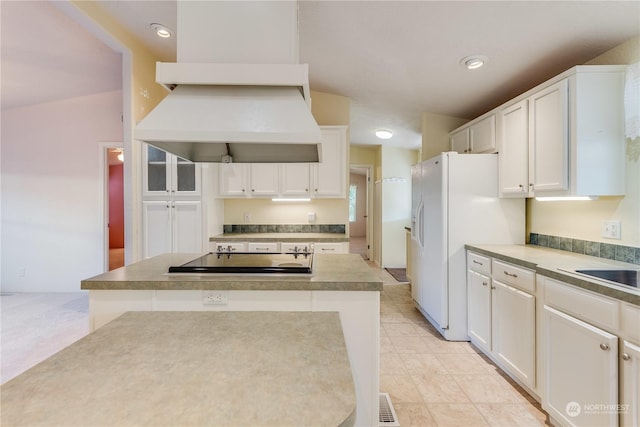 kitchen with white cabinets, a center island, white refrigerator with ice dispenser, and custom exhaust hood