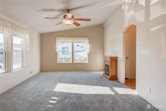 unfurnished living room featuring light carpet, ceiling fan, and lofted ceiling