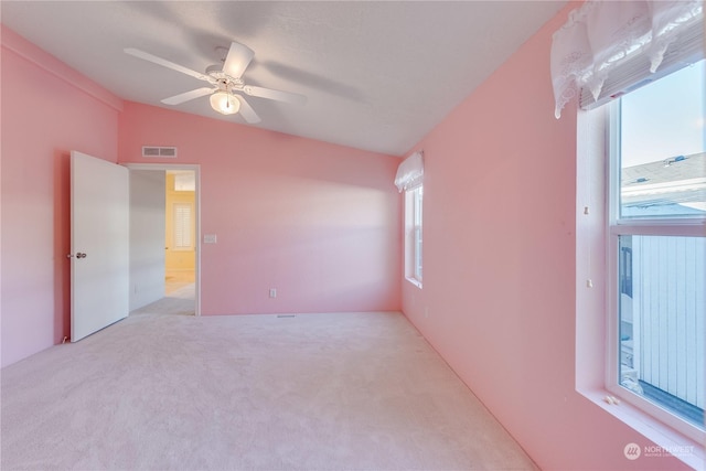 carpeted spare room with ceiling fan and vaulted ceiling