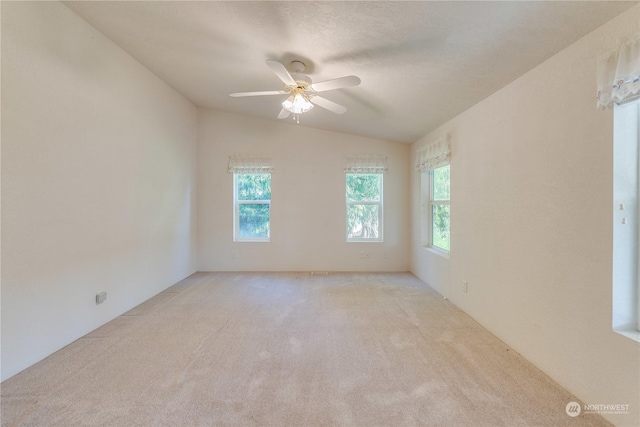 carpeted spare room featuring ceiling fan and lofted ceiling