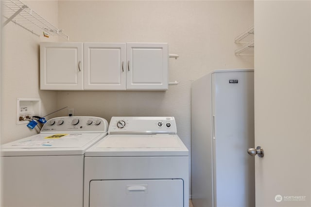 laundry area featuring washer and dryer and cabinets