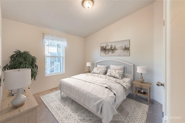 bedroom with carpet, a textured ceiling, and vaulted ceiling