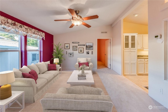 tiled living room featuring ceiling fan and vaulted ceiling