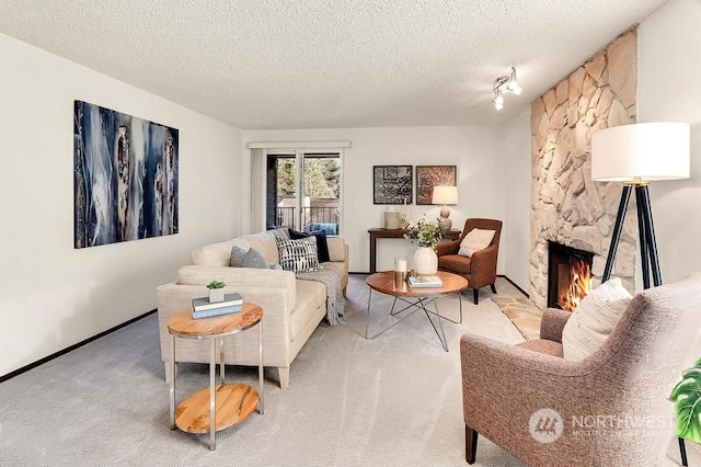 living room featuring a textured ceiling, a fireplace, and light carpet