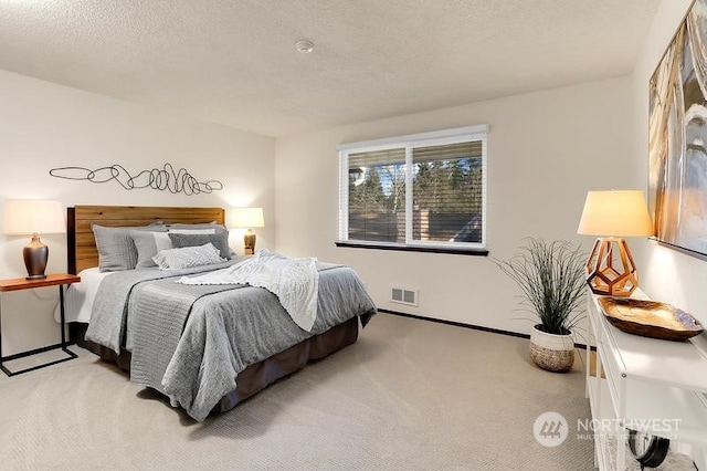 bedroom with light carpet and a textured ceiling