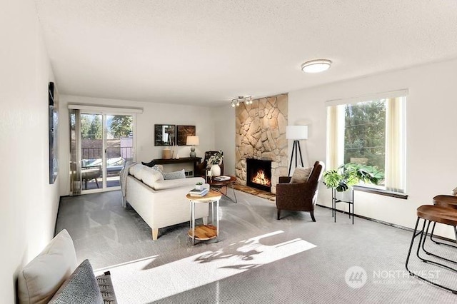 carpeted living room with a textured ceiling and a fireplace