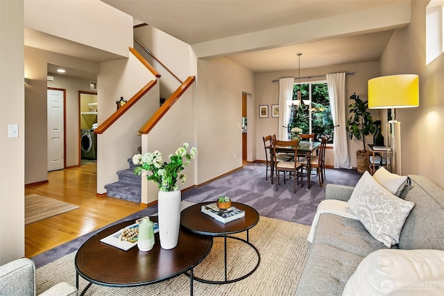 living area featuring baseboards, stairs, washer / clothes dryer, and wood finished floors