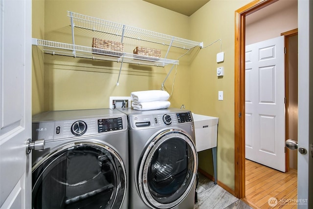 washroom featuring laundry area, washer and clothes dryer, and wood finished floors