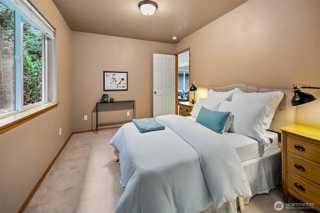 bedroom featuring light colored carpet and baseboards