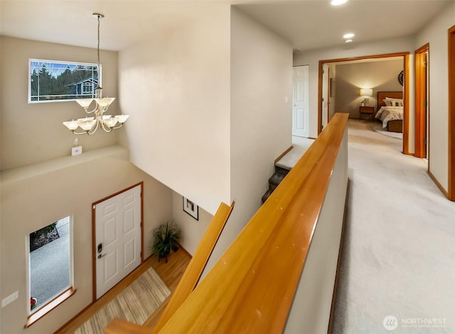 hallway featuring recessed lighting, carpet flooring, an upstairs landing, and an inviting chandelier