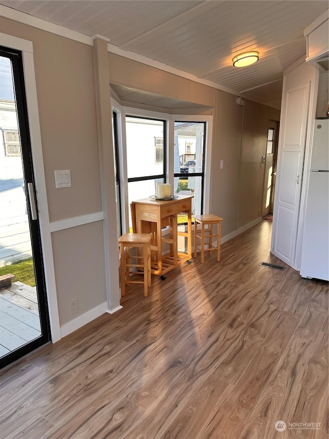 unfurnished dining area featuring hardwood / wood-style floors and ornamental molding