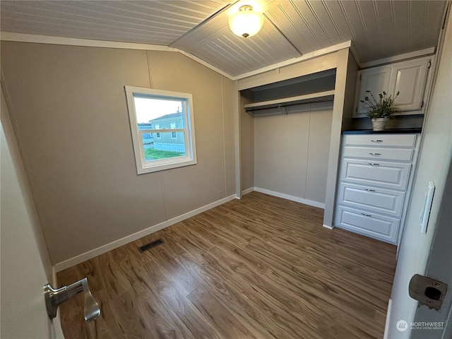 unfurnished bedroom with dark hardwood / wood-style floors, lofted ceiling, a closet, wood ceiling, and ornamental molding