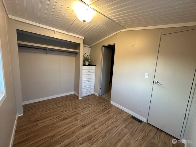 unfurnished bedroom featuring hardwood / wood-style floors, a closet, wooden ceiling, and vaulted ceiling