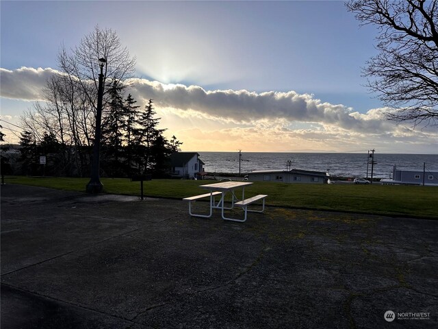 view of property's community featuring a lawn and a water view