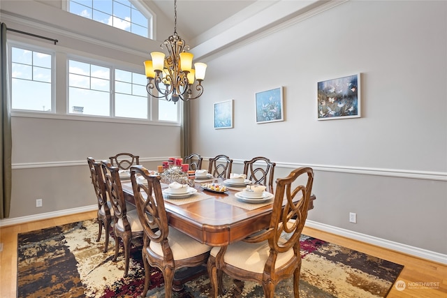 dining space featuring an inviting chandelier, vaulted ceiling, and hardwood / wood-style flooring