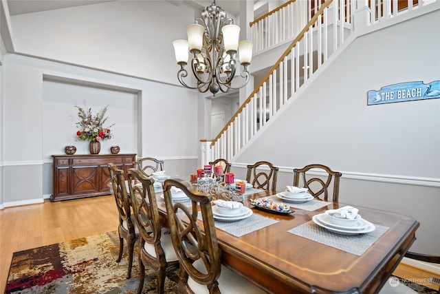 dining space featuring hardwood / wood-style floors, a chandelier, and lofted ceiling