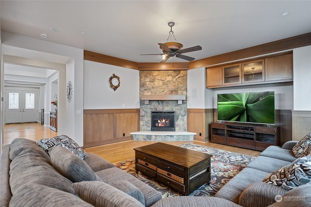 living room featuring ceiling fan, light hardwood / wood-style floors, and a fireplace