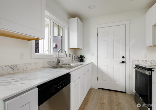 kitchen with light wood-type flooring, stainless steel dishwasher, sink, electric range, and white cabinets