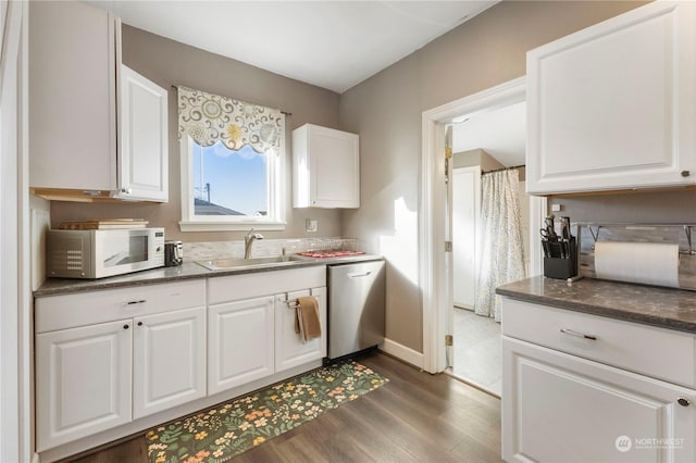 kitchen featuring sink, white cabinets, stainless steel dishwasher, and dark hardwood / wood-style floors