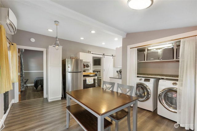 interior space featuring a wall unit AC, dark wood-type flooring, lofted ceiling with beams, separate washer and dryer, and a barn door