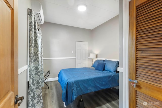 bedroom featuring hardwood / wood-style floors and a wall unit AC