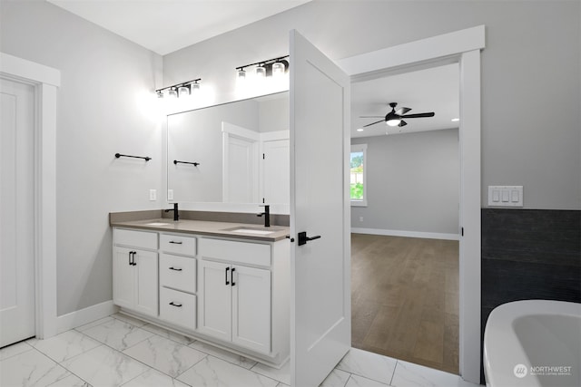 bathroom featuring hardwood / wood-style floors, ceiling fan, a tub, and vanity