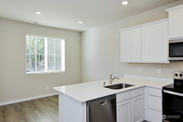 kitchen featuring white cabinetry, sink, kitchen peninsula, appliances with stainless steel finishes, and light wood-type flooring