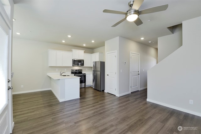 kitchen with kitchen peninsula, stainless steel appliances, white cabinetry, and dark hardwood / wood-style floors