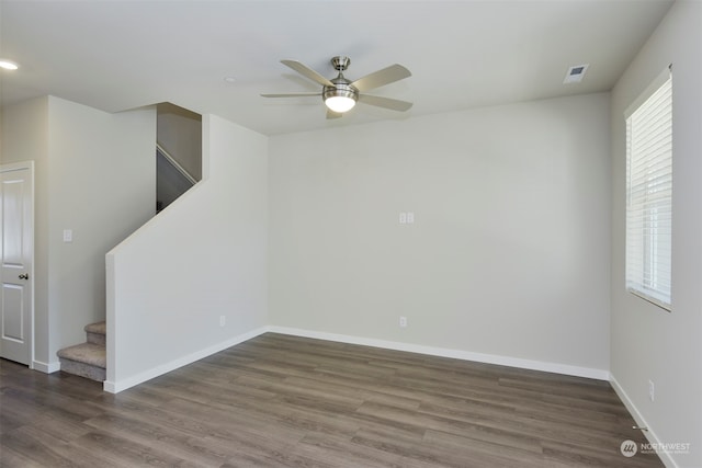 empty room with dark wood-type flooring and ceiling fan