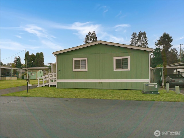 view of side of property with a carport and a yard