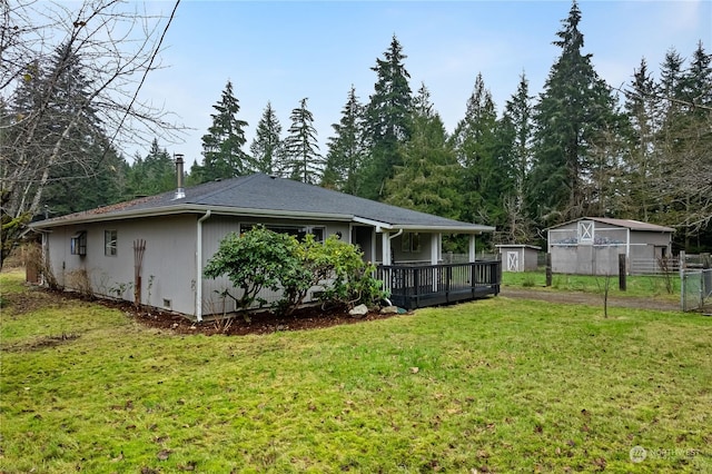 rear view of property featuring a storage shed and a lawn