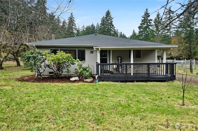 back of property featuring a wooden deck and a yard