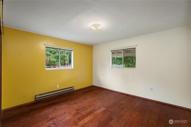 empty room featuring hardwood / wood-style flooring and a baseboard radiator