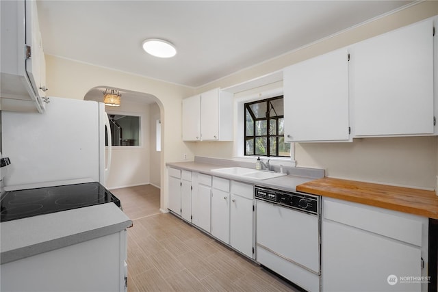 kitchen with white appliances, white cabinetry, and sink