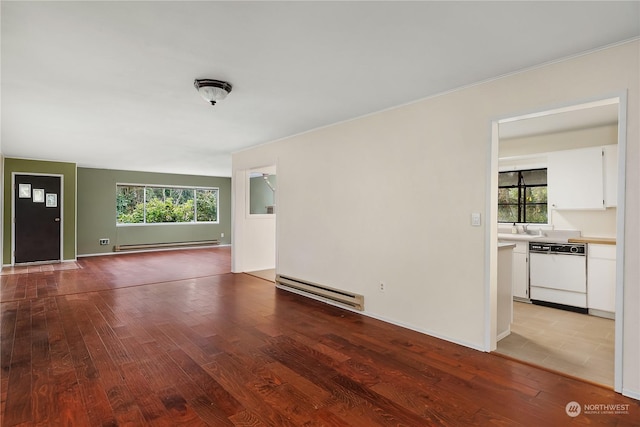 unfurnished living room with light wood-type flooring, sink, and a baseboard radiator