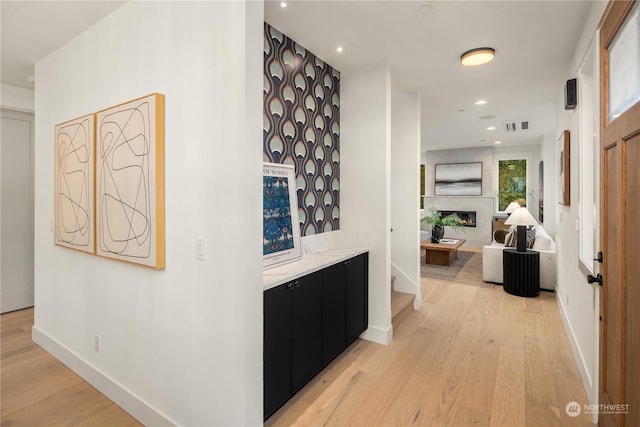 corridor with light hardwood / wood-style floors