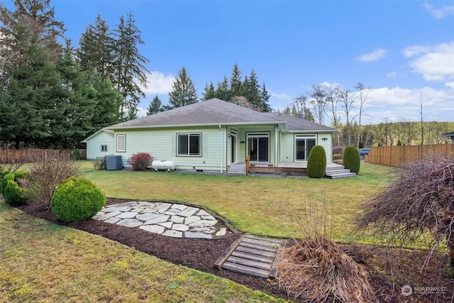 rear view of property featuring cooling unit and a yard