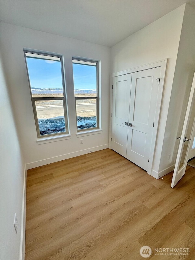 interior space featuring light wood finished floors and baseboards